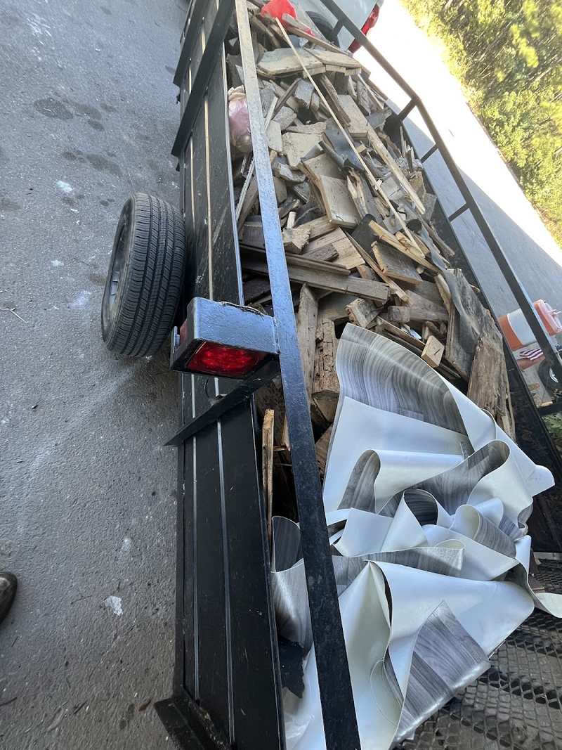 Utility trailer carrying construction wood and renovation debris.